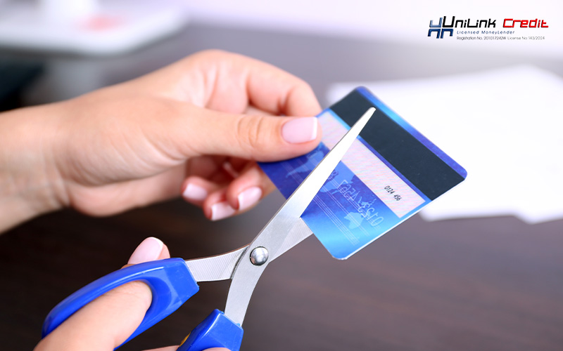 Woman cutting a credit card to get out of debt.